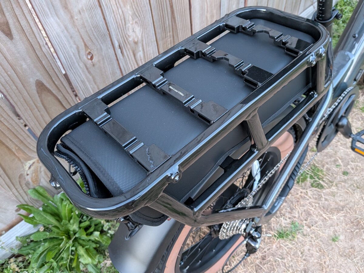 Rear bike rack with a black pannier bag secured by straps, mounted on the Velotric GoMad