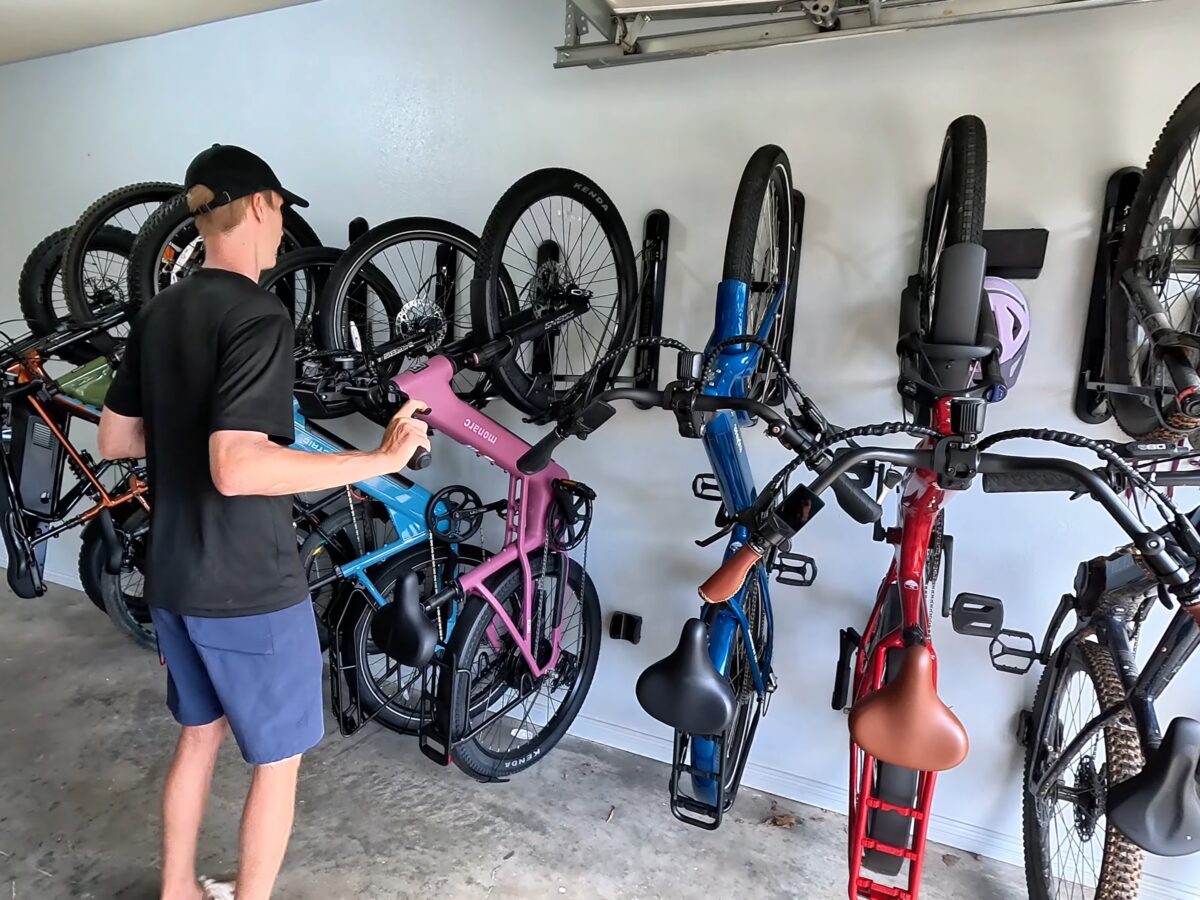 Ten electric bikes hanging on Steadyrack ProFlex racks on a garage wall