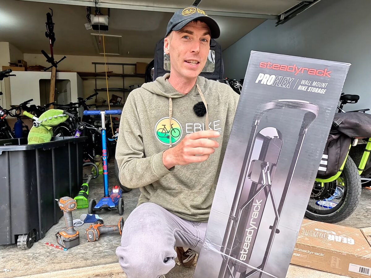 Myles holding a Steadyrack ProFlex box in a cluttered garage before installation