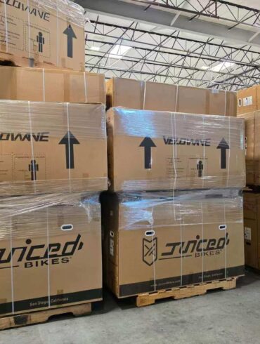 Pallets of boxed Juiced Bikes and Velowave ebikes stacked in Napune’s US warehouse